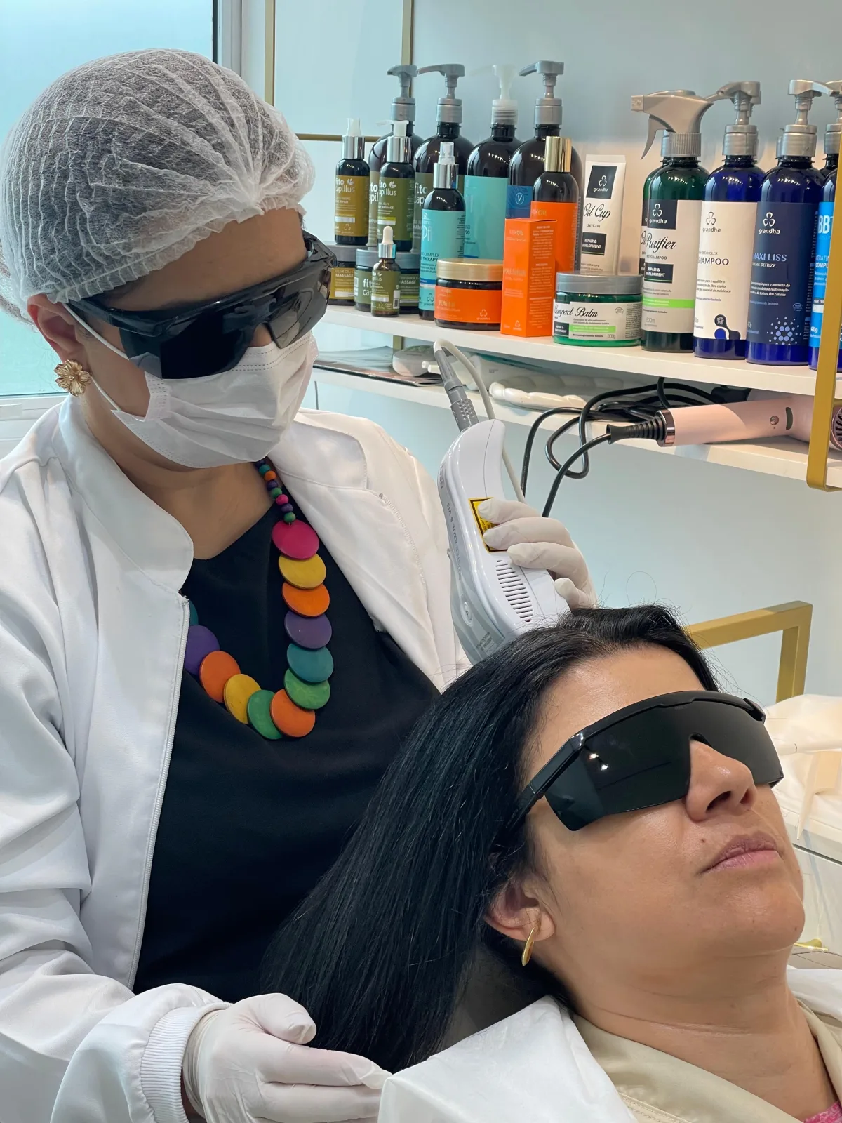 Ariana realizando procedimento de terapia capilar em uma cliente